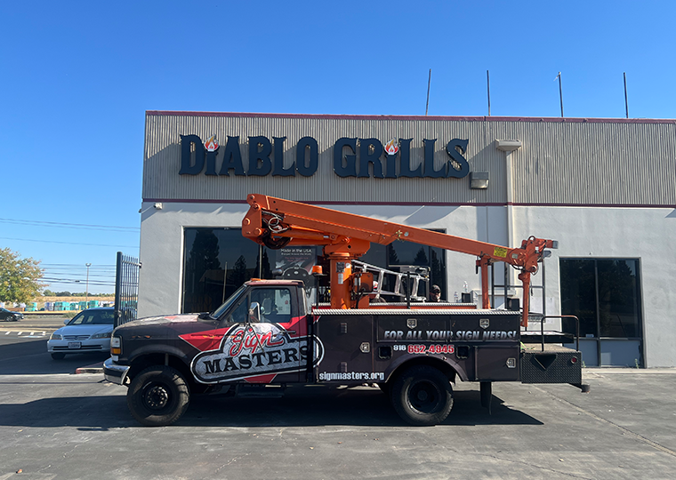 Custom business sign installation for Diablo Grills with Sign Masters service truck on site, Sacramento commercial signage and installation experts.